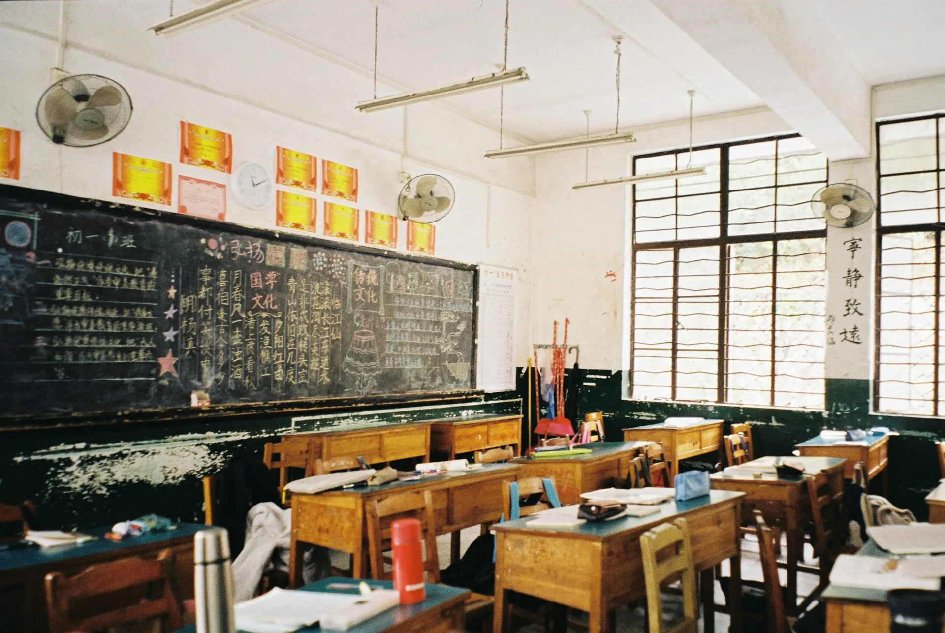 Aula di classe con diversi banchi e nua grossa lavagna con scritte in Giapponese