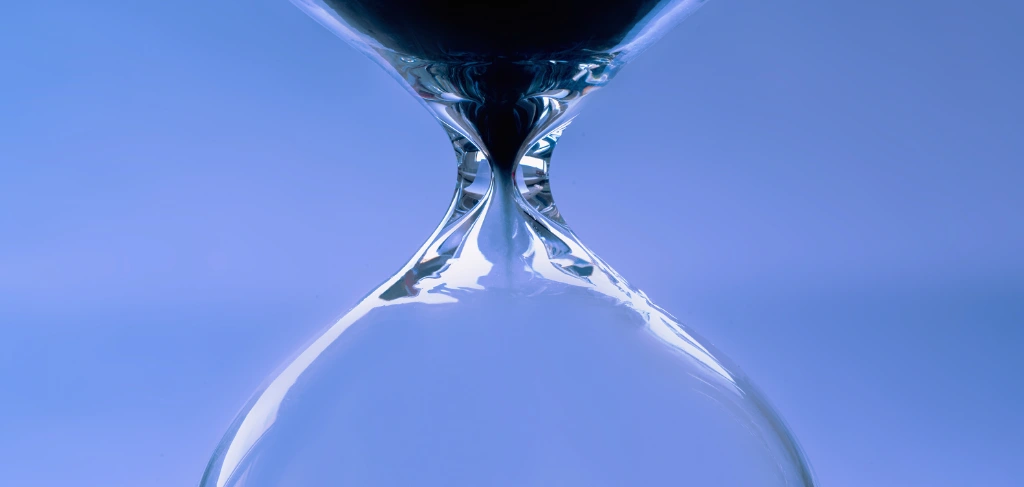 Clessidra di vetro trasparente con uno sfondo blu