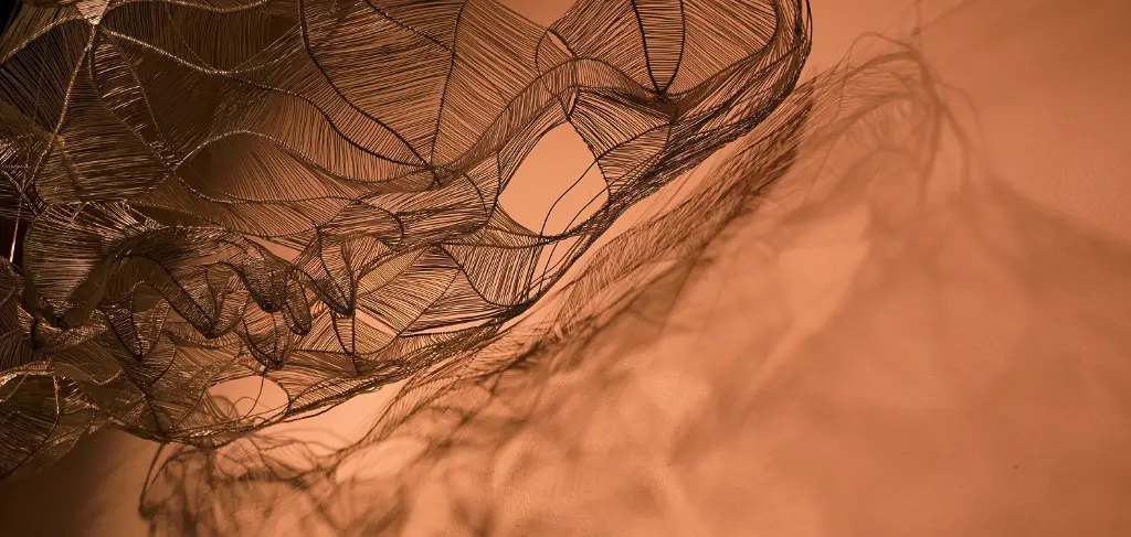 Rete nera su sfondo neutro color rosa antico con ombra proiettata sullo sfondo