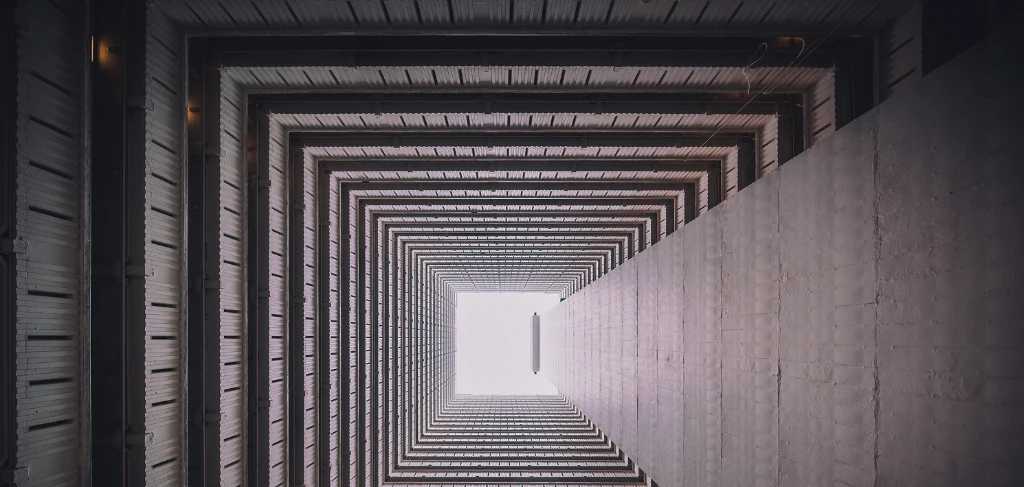 Corridoio grigio quadrato. Alla fine del corridoio si vede una luce bianca intensa